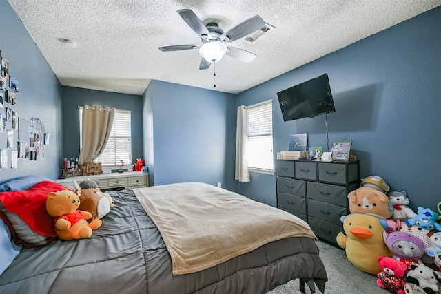 bedroom featuring ceiling fan, carpet flooring, and a textured ceiling