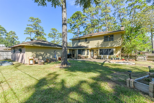 rear view of property featuring a patio and a lawn