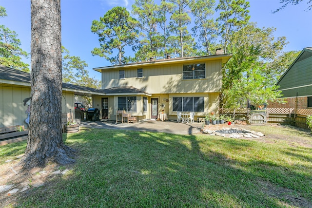 back of house with a patio and a lawn