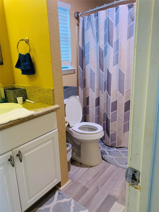 bathroom with vanity, toilet, hardwood / wood-style flooring, and curtained shower