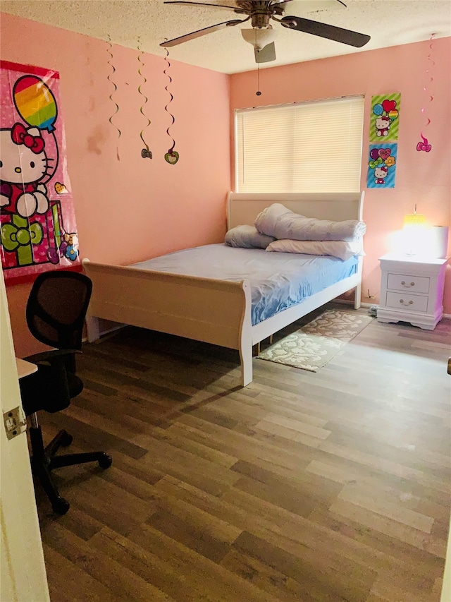 bedroom featuring hardwood / wood-style floors, a textured ceiling, and ceiling fan