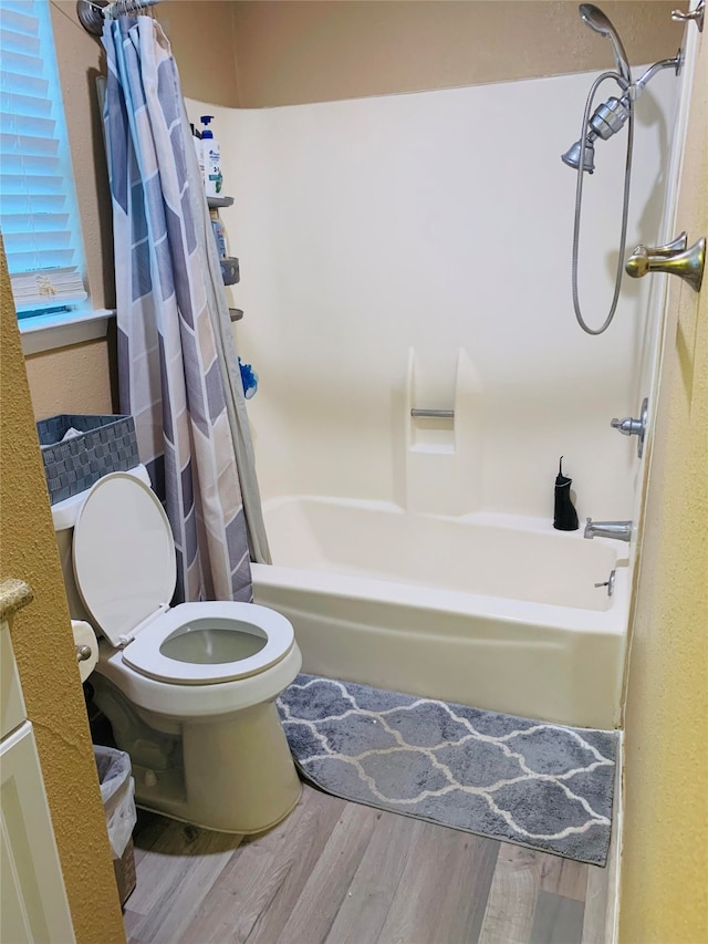 bathroom featuring shower / bath combo, wood-type flooring, and toilet