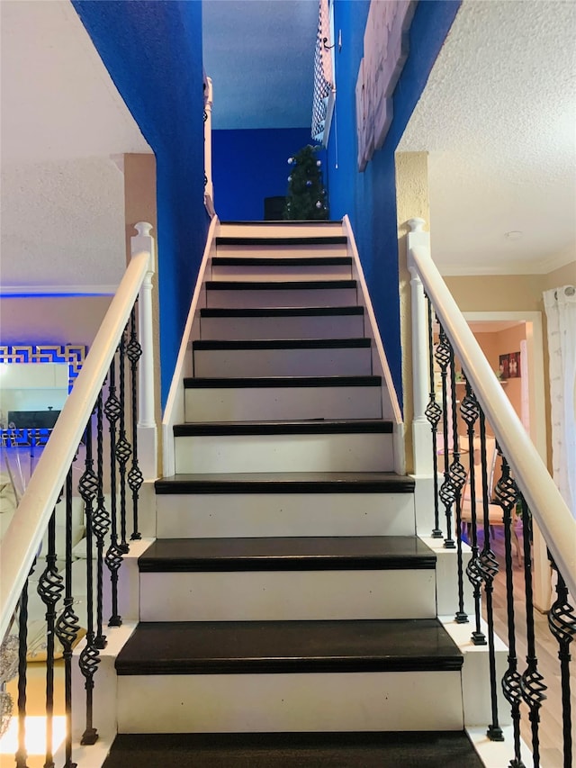 stairs with a textured ceiling and hardwood / wood-style flooring