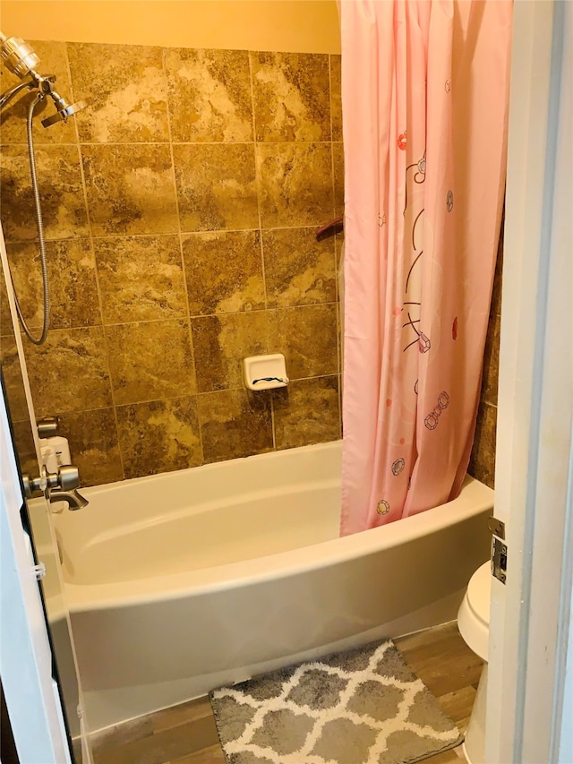 bathroom with toilet, shower / tub combo with curtain, and wood-type flooring