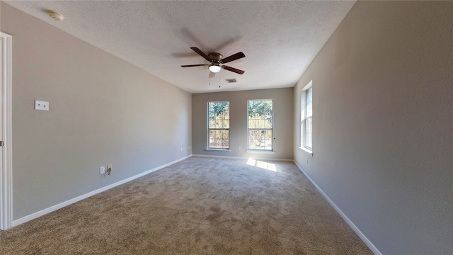 carpeted spare room featuring a textured ceiling and ceiling fan