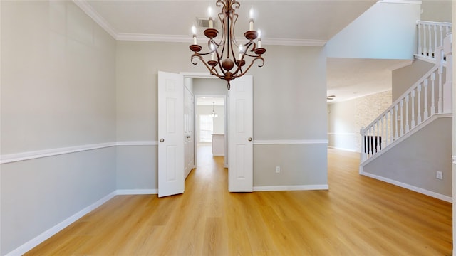 unfurnished room featuring ornamental molding, light hardwood / wood-style flooring, and an inviting chandelier