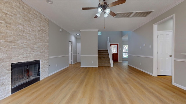 unfurnished living room with light hardwood / wood-style flooring, ceiling fan, a fireplace, and crown molding