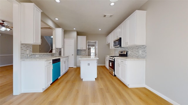 kitchen featuring a kitchen island, white cabinetry, stainless steel appliances, and light wood-type flooring