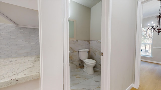 bathroom with toilet, ornamental molding, hardwood / wood-style flooring, and tile walls