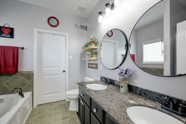 bathroom featuring vanity, a bathtub, toilet, and tile patterned floors