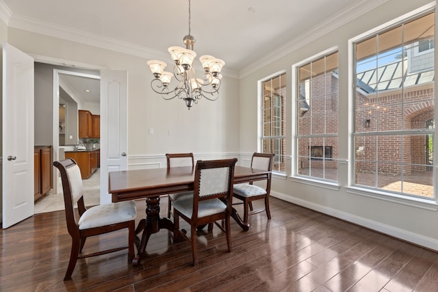 dining area with a notable chandelier, ornamental molding, and dark hardwood / wood-style flooring