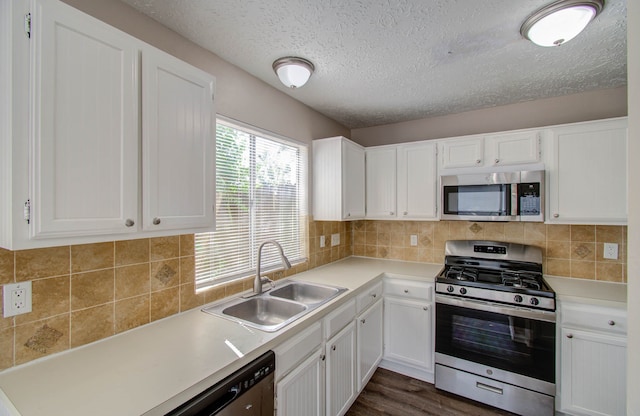 kitchen with decorative backsplash, white cabinets, dark hardwood / wood-style floors, sink, and stainless steel appliances