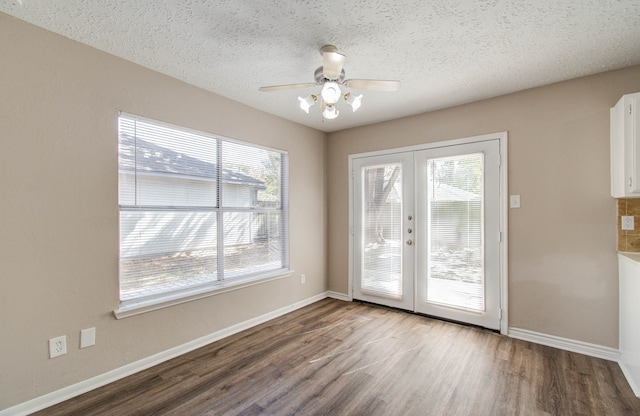 interior space featuring french doors, hardwood / wood-style floors, a textured ceiling, and a wealth of natural light