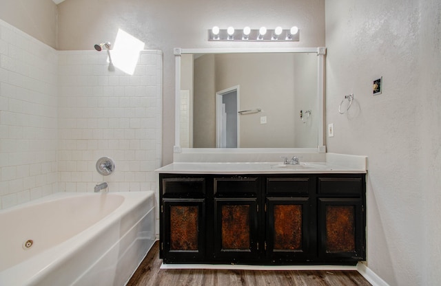 bathroom with tiled shower / bath, vanity, and wood-type flooring