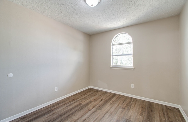 unfurnished room featuring hardwood / wood-style floors and a textured ceiling