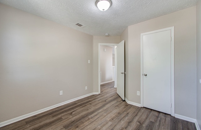 unfurnished bedroom featuring a textured ceiling and wood-type flooring