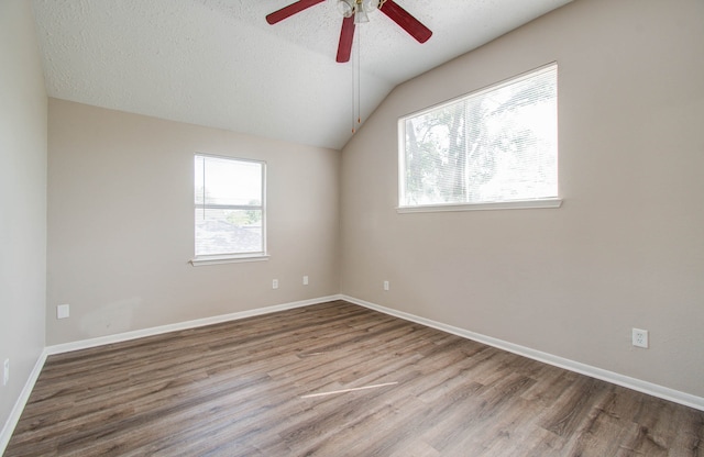 empty room featuring light hardwood / wood-style flooring, a textured ceiling, vaulted ceiling, and ceiling fan