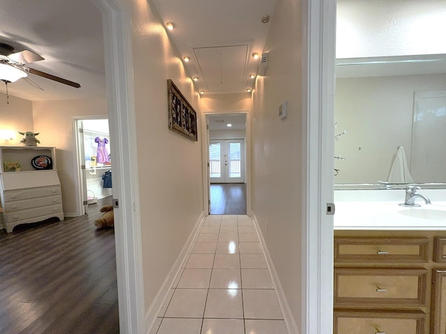 hallway featuring sink and light tile patterned floors