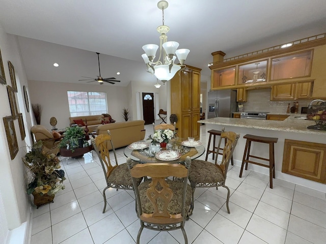 dining room featuring vaulted ceiling, sink, ceiling fan with notable chandelier, and light tile patterned floors