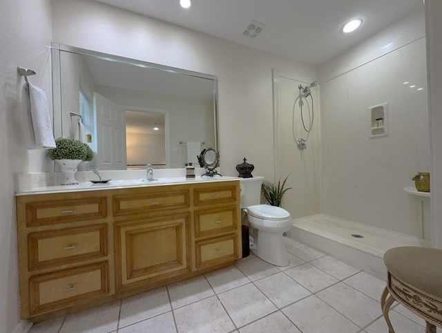 bathroom with vanity, tile patterned flooring, a shower, and toilet