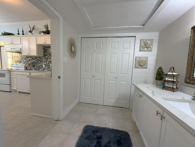 bathroom with tile patterned flooring, sink, and decorative backsplash