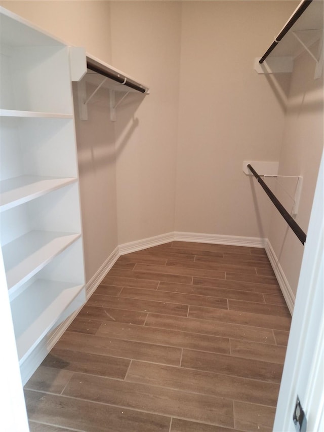 spacious closet with dark hardwood / wood-style floors