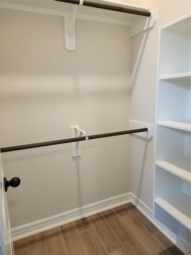 spacious closet with dark wood-type flooring