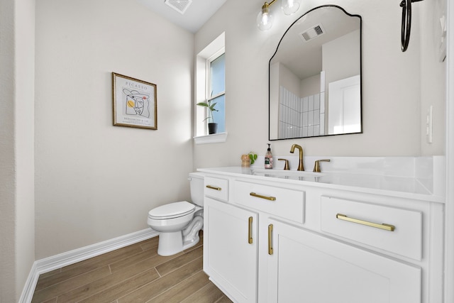 bathroom featuring toilet, vanity, and hardwood / wood-style flooring