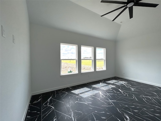 unfurnished room with vaulted ceiling, marble finish floor, and baseboards