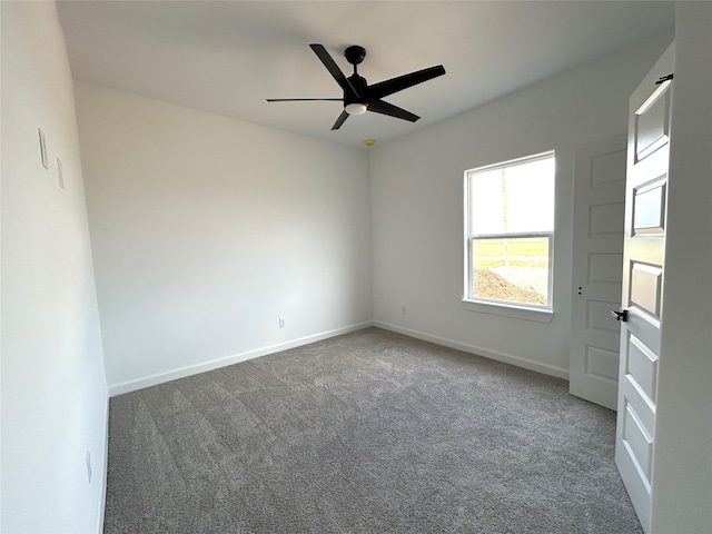 carpeted empty room with a ceiling fan and baseboards