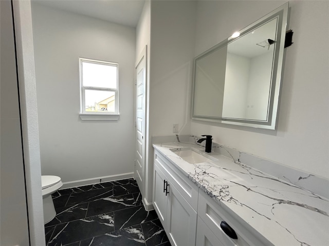 bathroom featuring marble finish floor, toilet, vanity, and baseboards