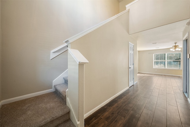 staircase with wood-type flooring and ceiling fan