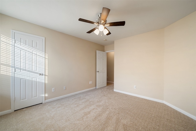 carpeted spare room featuring ceiling fan