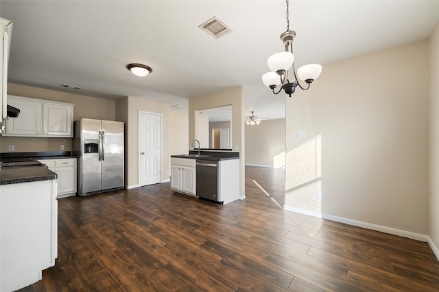 kitchen with dark wood-type flooring, appliances with stainless steel finishes, and white cabinetry