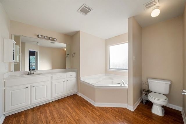 bathroom featuring vanity, wood-type flooring, toilet, and a bathing tub