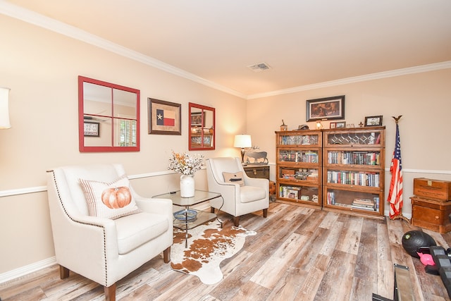 sitting room with hardwood / wood-style flooring and crown molding