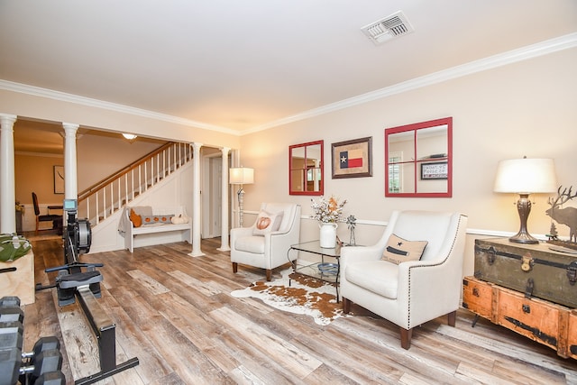 living room with ornamental molding, hardwood / wood-style flooring, and decorative columns