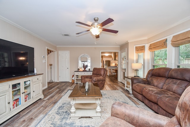 living room with ceiling fan, wood-type flooring, and ornamental molding