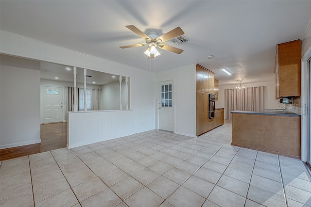 interior space with light tile patterned flooring and ceiling fan with notable chandelier