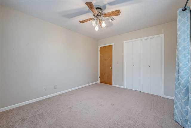 unfurnished bedroom with light carpet, a closet, and ceiling fan