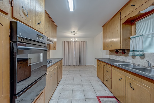 kitchen with hanging light fixtures, light tile patterned floors, stainless steel gas stovetop, a notable chandelier, and sink