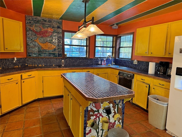 kitchen featuring dark tile patterned flooring, sink, a center island, white fridge, and decorative backsplash