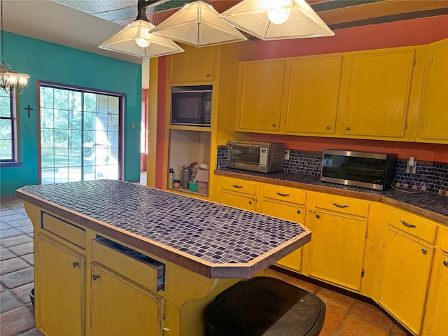 kitchen with black microwave and ceiling fan with notable chandelier