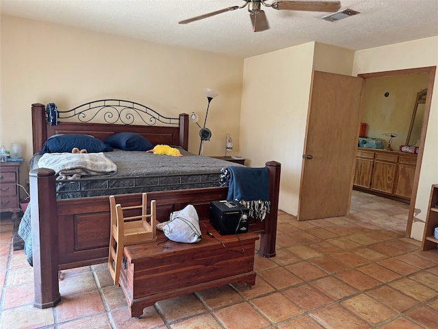 bedroom with ceiling fan and a textured ceiling