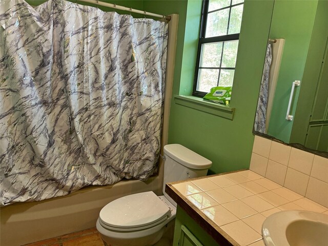 full bathroom with vanity, shower / tub combo, toilet, and tasteful backsplash