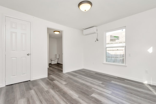 empty room featuring light hardwood / wood-style flooring and a wall mounted air conditioner