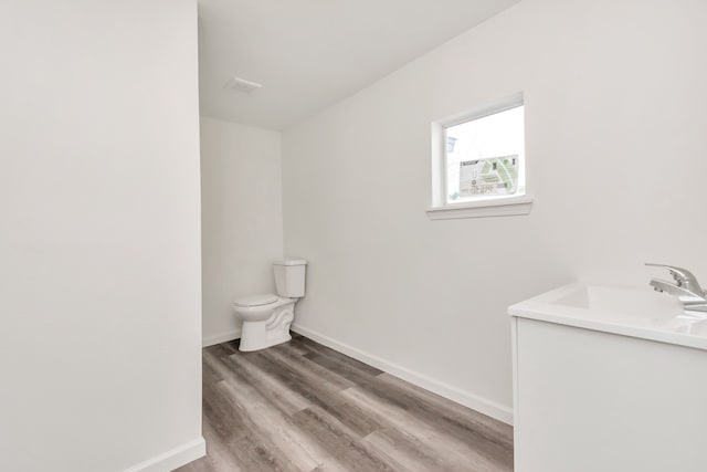 bathroom featuring vanity, toilet, and hardwood / wood-style floors