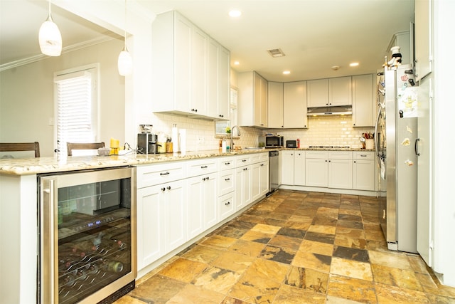 kitchen with white cabinetry, hanging light fixtures, wine cooler, backsplash, and stovetop