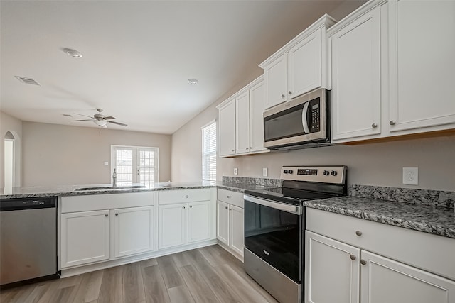 kitchen featuring kitchen peninsula, stainless steel appliances, sink, light wood-type flooring, and white cabinetry