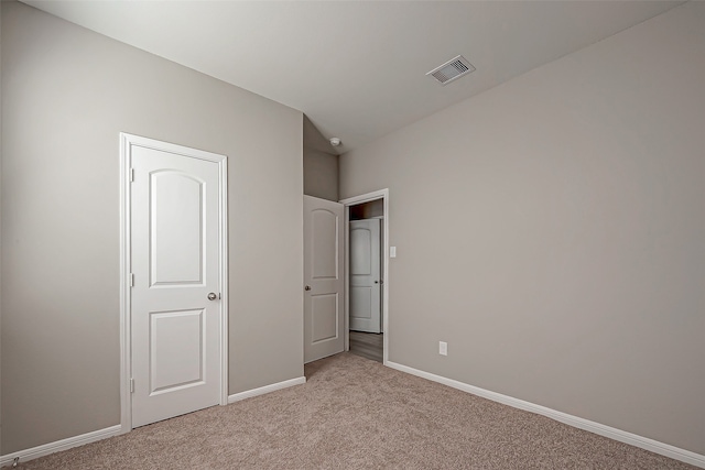 unfurnished bedroom with light carpet and vaulted ceiling